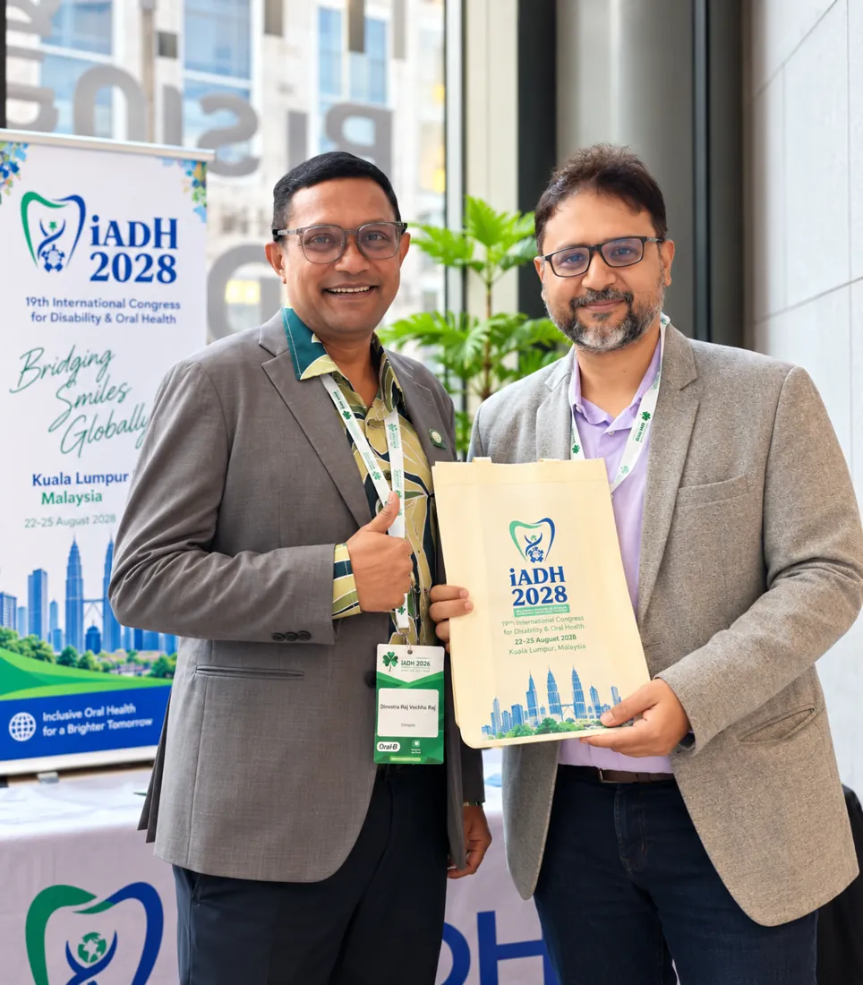 Dr. Sanchit Paul beside the banner for the 2028 International Association for Disability and Oral Health congress