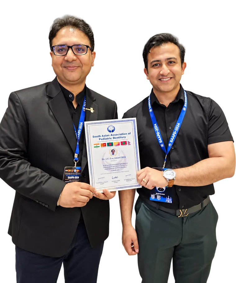 Dr. Sanchit Paul (left) holding the Dr. J.C. Lee Award 2024 certificate of the South Asian Association of Pediatric Dentistry, with a colleague